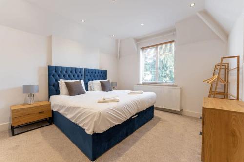 een slaapkamer met een groot blauw bed en een raam bij Spacious 3 Bedroom house, 10 mins to Birmingham in Birmingham