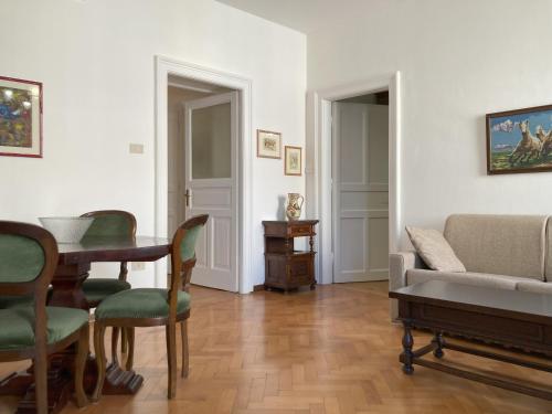 uma sala de estar com um sofá, uma mesa e cadeiras em Gli Acquerelli em Trieste