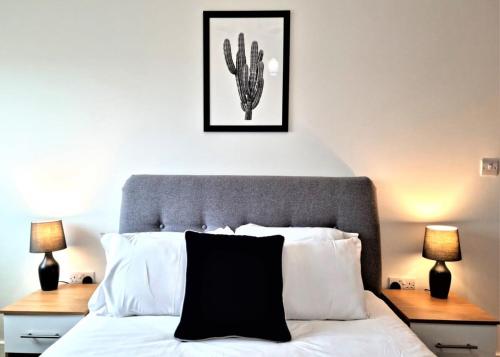 una camera con un letto bianco e nero con due lampade di Luxury 1 bed apartment 10 mins from Bham City Centre a Birmingham