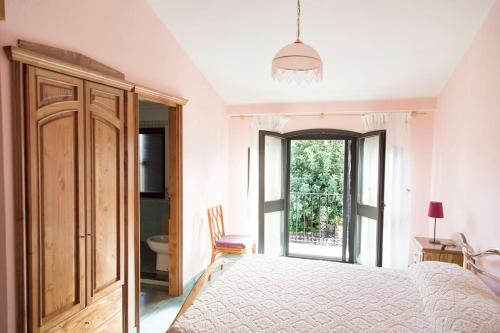 a white bedroom with a bed and a window at Bari Sardo Suite Padronale in Bari Sardo