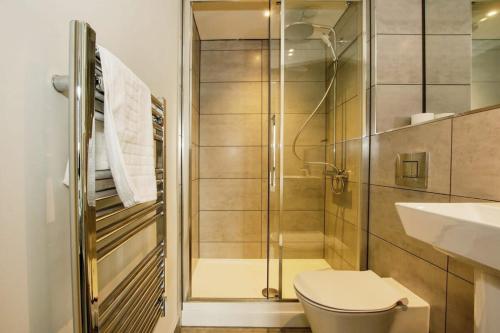 a bathroom with a shower and a toilet and a sink at St Martin's Place Apartment - Bham City Centre in Birmingham