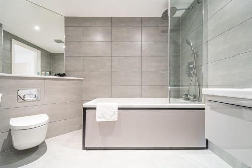 ein Badezimmer mit einer Badewanne, einem WC und einem Waschbecken in der Unterkunft Modern Studio Apartment - Solihull by Seven Stays in Solihull