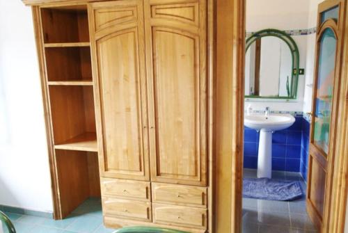 a wooden cabinet in a bathroom with a sink at Bari Sardo Suite Padronale in Bari Sardo
