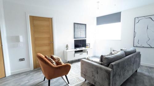sala de estar con sofá y silla en Modern 2 Bed Apt - 15 Mins to Birmingham Centre, en Birmingham