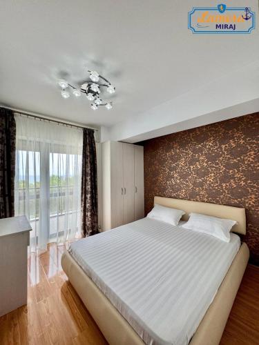 een slaapkamer met een groot bed en een groot raam bij Lamera-Miraj sea view in Mamaia