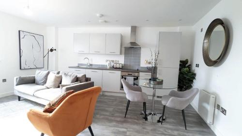 uma sala de estar com um sofá, uma mesa e cadeiras em Luxury 2 Bed Apt - 15 Mins to Central Birmingham em Birmingham