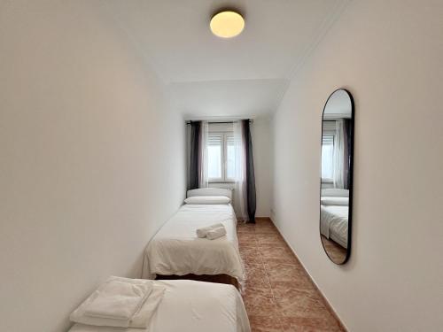 eine Reihe von Betten in einem Zimmer mit Spiegel in der Unterkunft Pink Panther in A Coruña