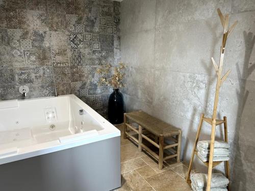 La salle de bains est pourvue d'une baignoire blanche et d'un vase de fleurs. dans l'établissement Villa Marie - Domaine Cavalery, à Pertuis