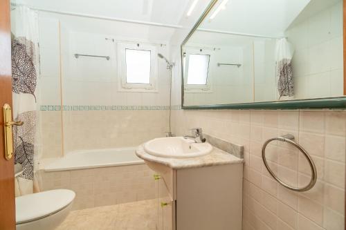 a bathroom with a sink and a tub and a mirror at Casa para vacaciones perfectas in Vilassar de Mar