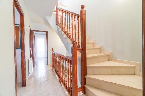 a staircase with wooden railings in a house at Casa para vacaciones perfectas in Vilassar de Mar
