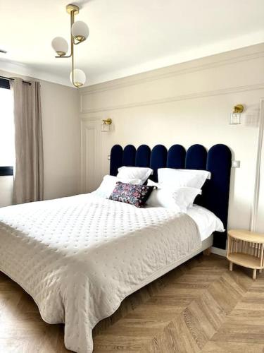 une chambre avec un grand lit avec une tête de lit bleue dans l'établissement Villa Marie - Domaine Cavalery, à Pertuis