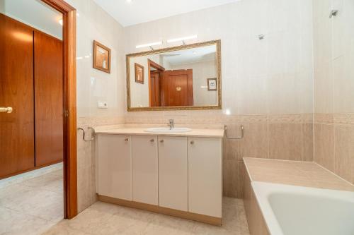 a bathroom with a sink and a mirror and a tub at Casa para vacaciones perfectas in Vilassar de Mar