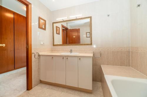 a bathroom with a sink and a mirror and a tub at Casa para vacaciones perfectas in Vilassar de Mar