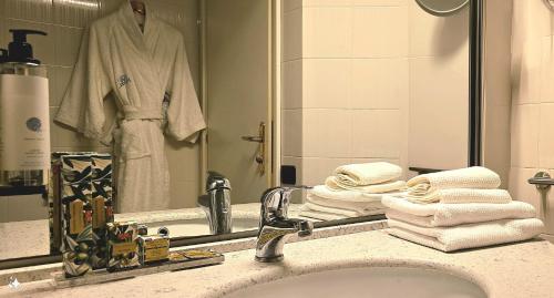 een badkamer met een wastafel, een spiegel en handdoeken bij Parc Hotel in Poppi