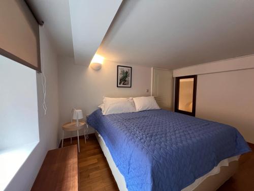 sypialnia z niebieskim łóżkiem i oknem w obiekcie SOLOMOU APARTMENT w Korfu