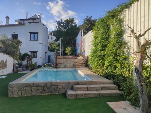 een zwembad in de tuin van een huis bij El molino del abuelo in Montecorto