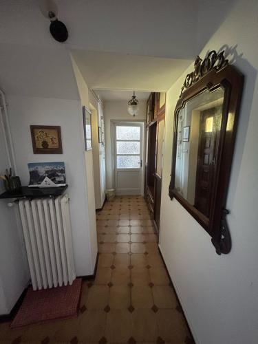 a hallway of a house with a mirror and a radiator at Casa Zio Zeffy in Châtillon