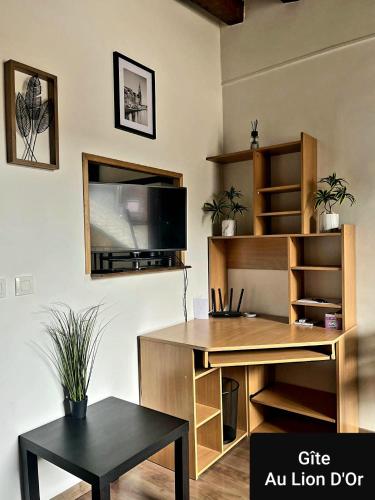 - un bureau avec un bureau et une télévision murale dans l'établissement Au Lion d'Or, à Les Roches-lʼÉvêque