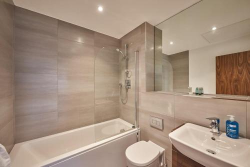 a bathroom with a toilet and a tub and a sink at SevenStays Bham city centre 1 bed - free parking in Birmingham