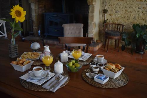 een tafel met ontbijtproducten en sinaasappelsap erop bij Aisina Portateni 