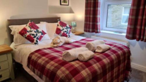 a bedroom with a bed with towels on it at Butterside Cottage in Burtersett near Hawes in Hawes