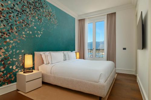 sypialnia z łóżkiem i dużym oknem w obiekcie Porto Palace w mieście Tivat