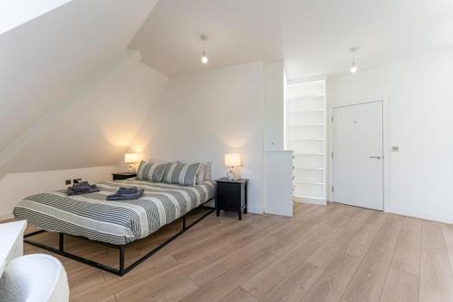 a white bedroom with a bed and two lamps at Contemporary 2 Bed Apartment Solihull NEC BHX in Solihull
