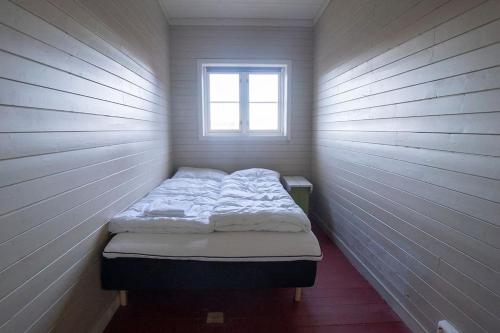 a small bed in a room with a window at Fisherman's cabin, Lofoten - 26 Ivarbua in Ballstad