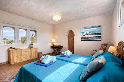 two beds in a room with two windows at La Agüita in playa del Águila