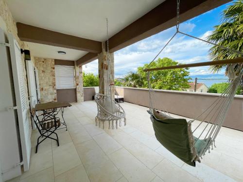a porch with a hammock on a balcony at Private Villa SoulSet with swimming pool in Vantačići