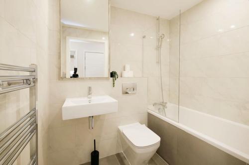 a white bathroom with a sink and a toilet at Brand New 1 Bed Apt - Seven Stays Bracknell in Bracknell