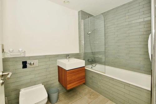 een badkamer met een wastafel, een toilet en een bad bij Contemporary 2 bedroom apartment - Ashford in Ashford