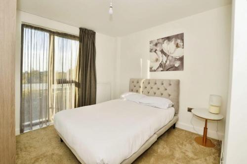 een witte slaapkamer met een bed en een raam bij Contemporary 2 bedroom apartment - Ashford in Ashford