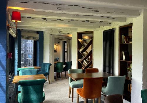 a dining room with tables and chairs and bookshelves at Thatchers, BW Signature Collection in East Horsley
