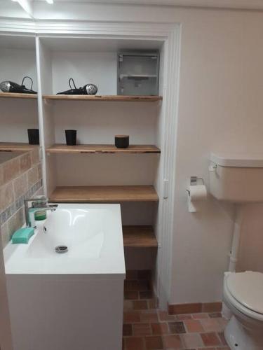 une salle de bain avec un lavabo blanc et des toilettes dans l'établissement Gîte Maria, à Saint-Hilaire-de-Riez