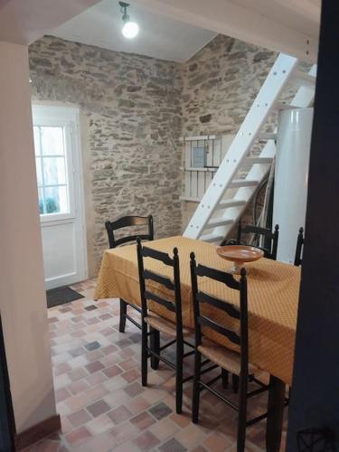 une salle à manger avec une table et des chaises et un escalier dans l'établissement Gîte Maria, à Saint-Hilaire-de-Riez