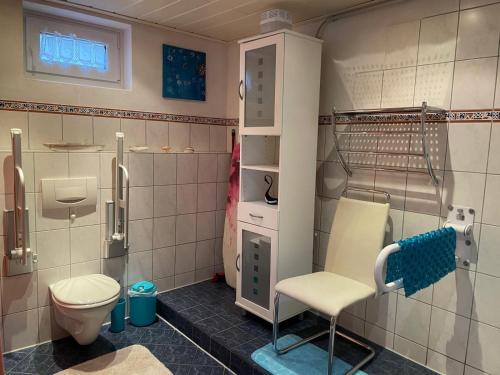 a bathroom with a toilet and a chair in it at Ferienwohnung Behrens in Celle