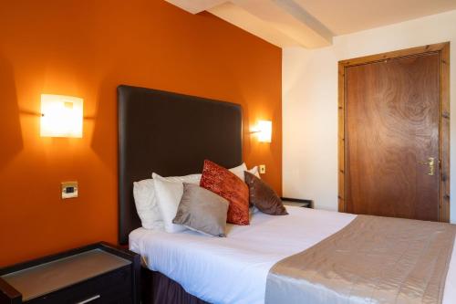 a bedroom with a bed with an orange wall at The Warehouse in Yeovil