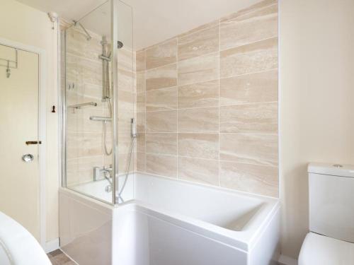 a white bathroom with a tub and a shower at 2 Bed in Yanwath SZ085 in Penrith