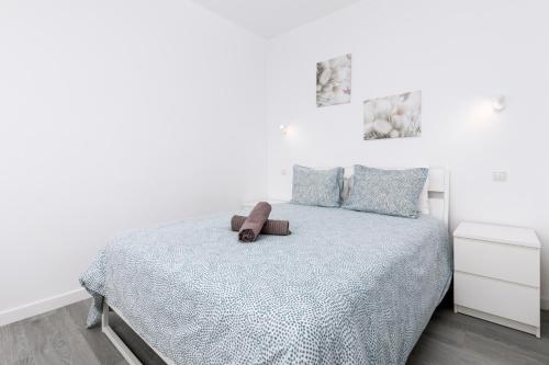 een witte slaapkamer met een bed met een bruine gordel erop bij La Lajita Barca Beach in Lajita