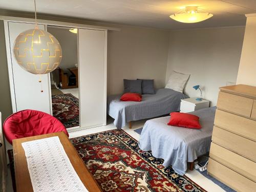 a room with two beds and a chair and a mirror at Nice house with a panoramic view of the sea on beautiful Hasslo outside Karlskrona in Karlskrona