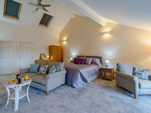 a bedroom with a bed and two chairs and a couch at 1 bed in Cartmel 85499 in Cark