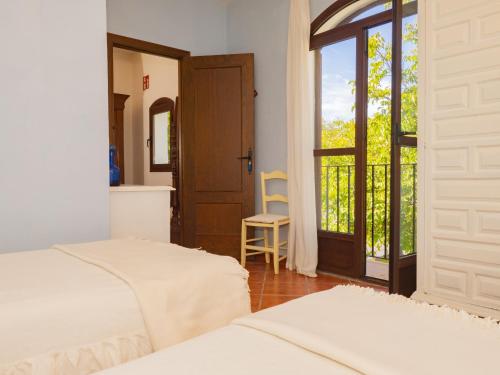 1 dormitorio con 2 camas y puerta corredera de cristal en Cubo's La Cimada Room 3 Bed&Breakfast, en Ronda