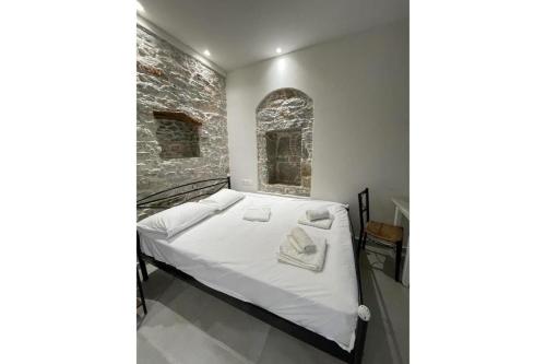 Cama en habitación con pared de ladrillo en Politimis Studio N6 en Amorgos