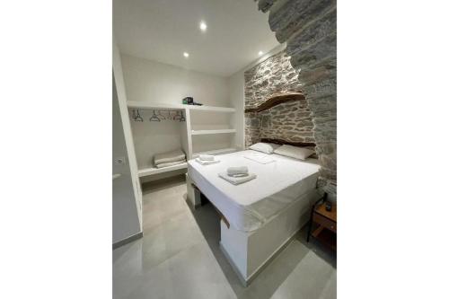 1 dormitorio con cama y pared de ladrillo en Politimis Studio N6 en Amorgos
