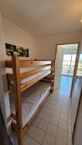 une chambre avec deux lits superposés dans une pièce dans l'établissement LES CAPITELLES - Studio cabine - Piscine - plage à 50 m Ref Noga, à Saint-Cyprien