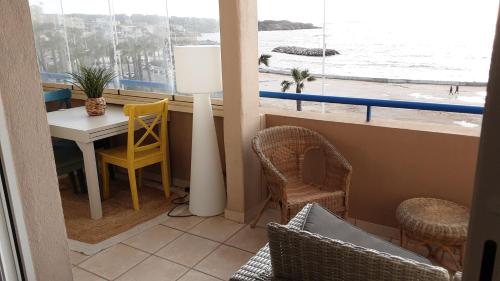 Cette chambre comprend une table et des chaises et offre une vue sur l'océan. dans l'établissement Appt T3 VUE MER, à Six-Fours-les-Plages