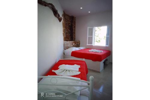 Habitación pequeña con 2 camas y ventana en Politimis Studio N1 en Amorgós