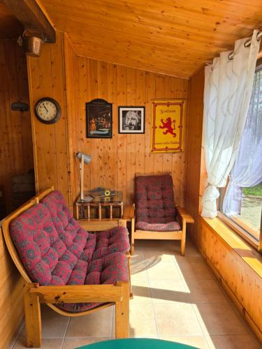 a living room with a couch and a clock at Chalet Natura la taverna dei 3 porcellini in Cavaliere