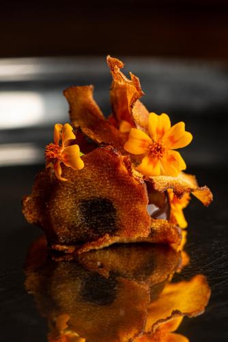 a piece of food with yellow flowers on a table at Balthazar Design Hotel in Kraków
